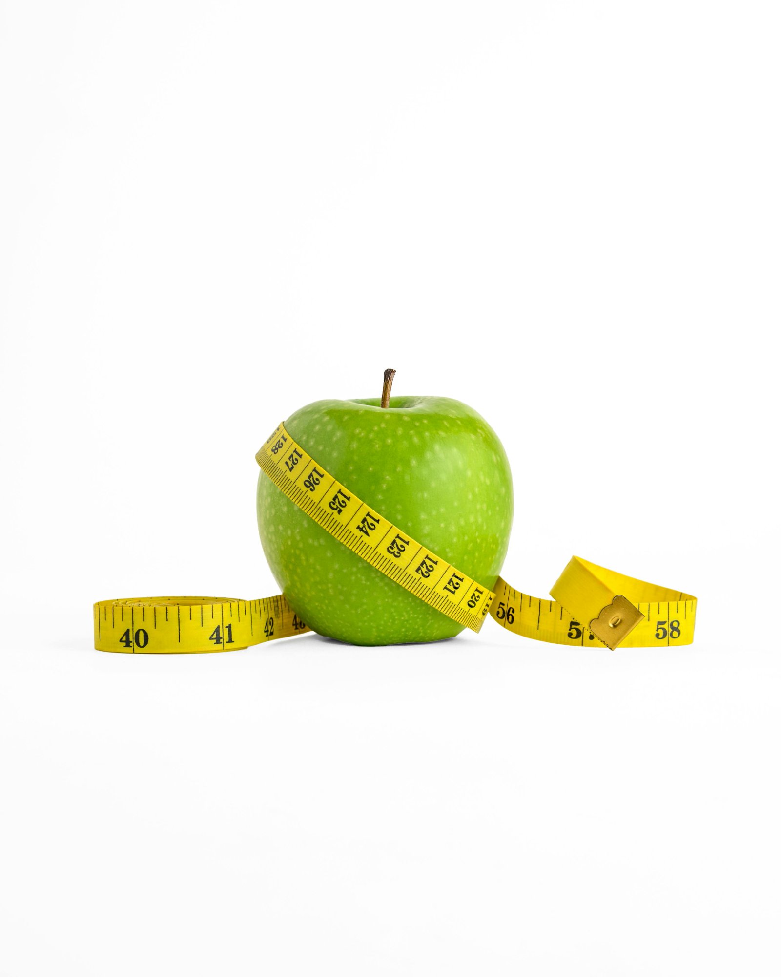 Green apple with measuring tape